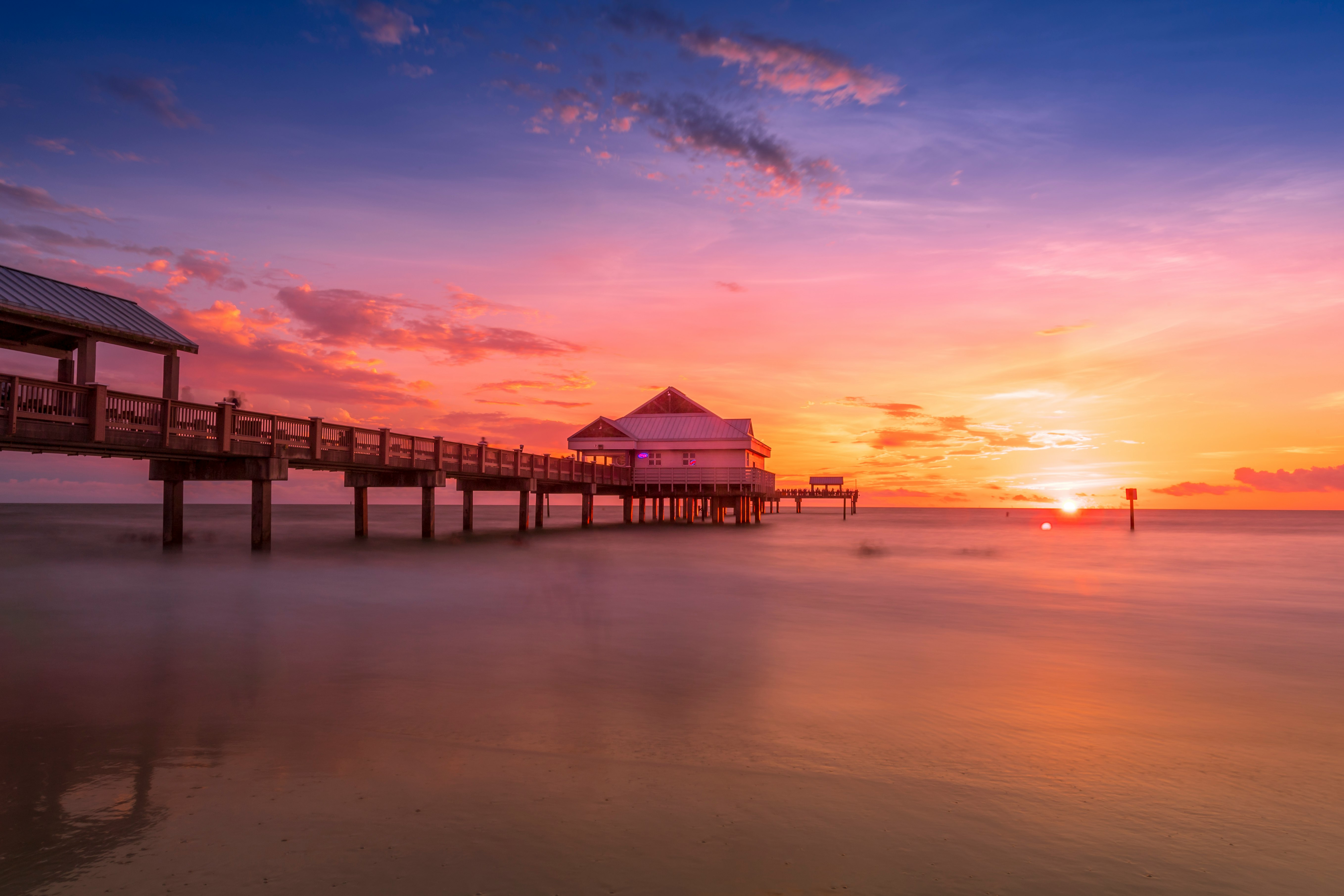 brown wooden dock on sea during sunset