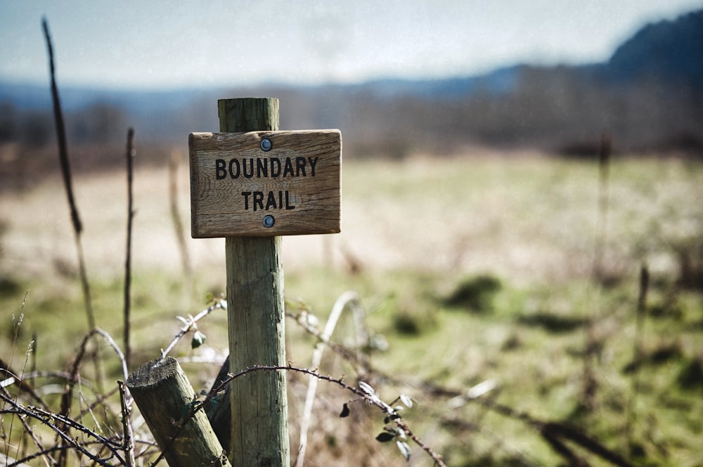 Signalisation en bois marron sur clôture en bois marron pendant la journée