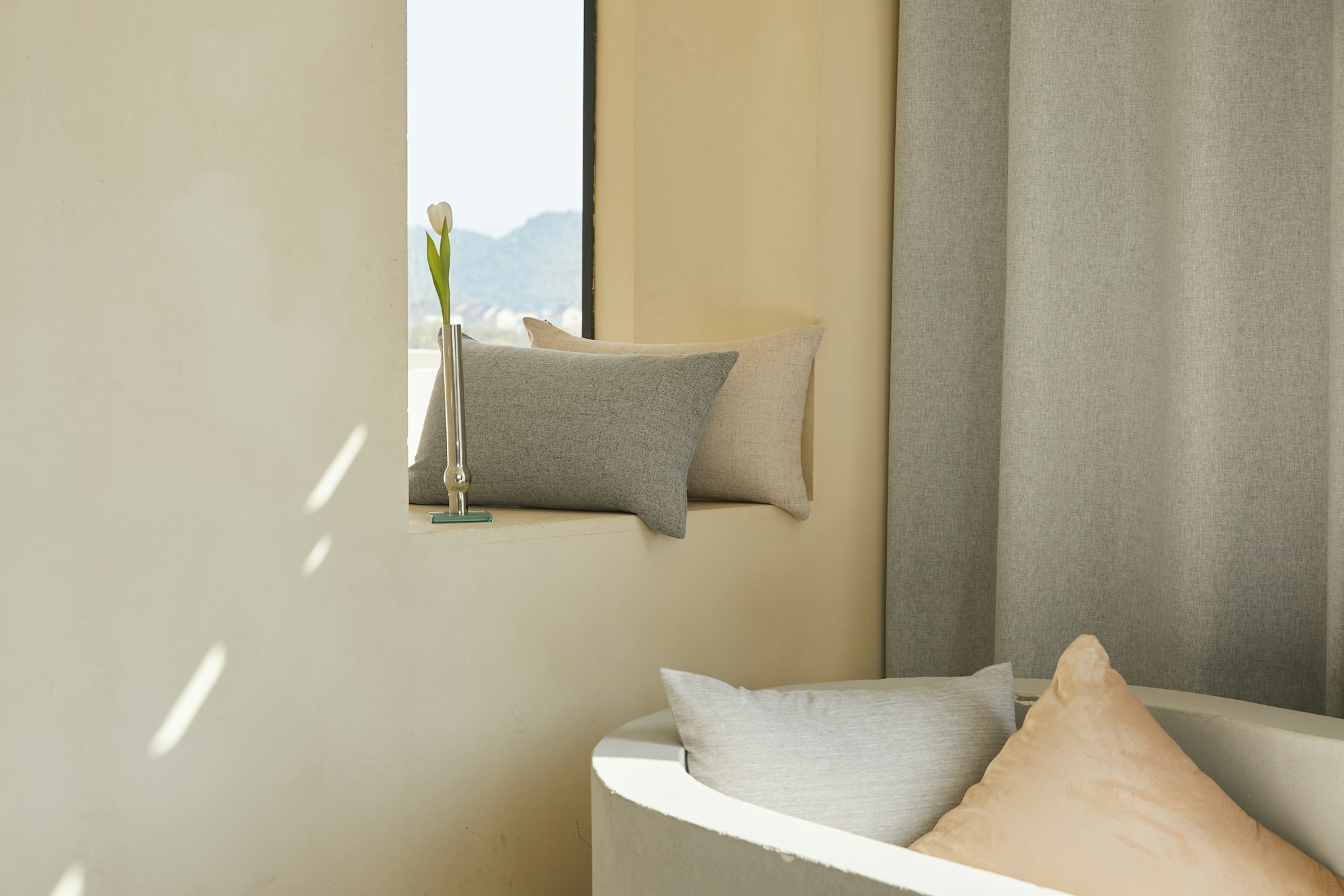cream colored cushions next to a pastel orange wall