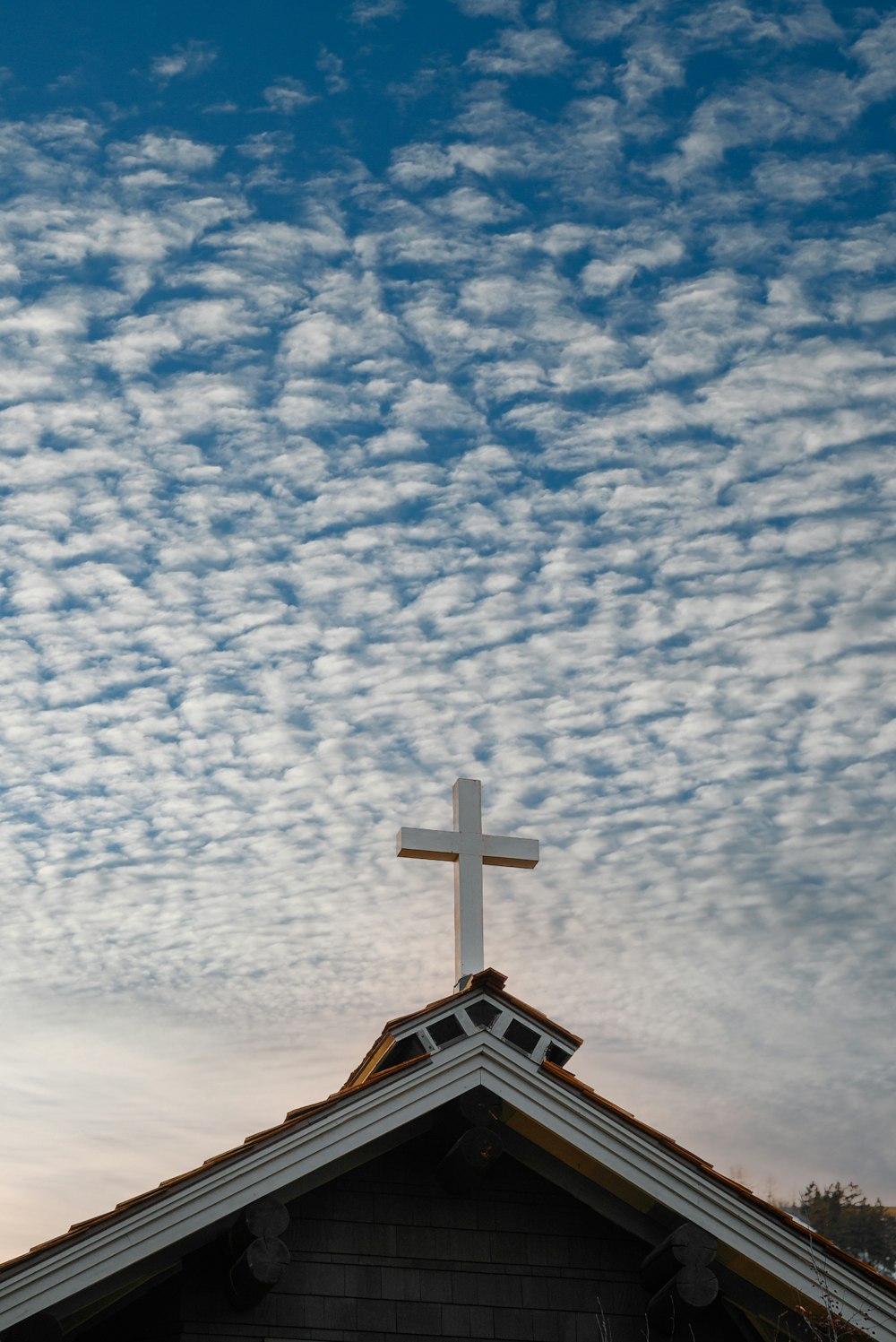 낮에는 푸른 하늘과 흰 구름 아래 갈색과 흰색 교회
