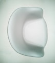 A smooth, modern chair with a minimalist design featuring curved edges and a shiny surface. The chair is predominantly white, set against a pale background, emphasizing its elegant and contemporary style.