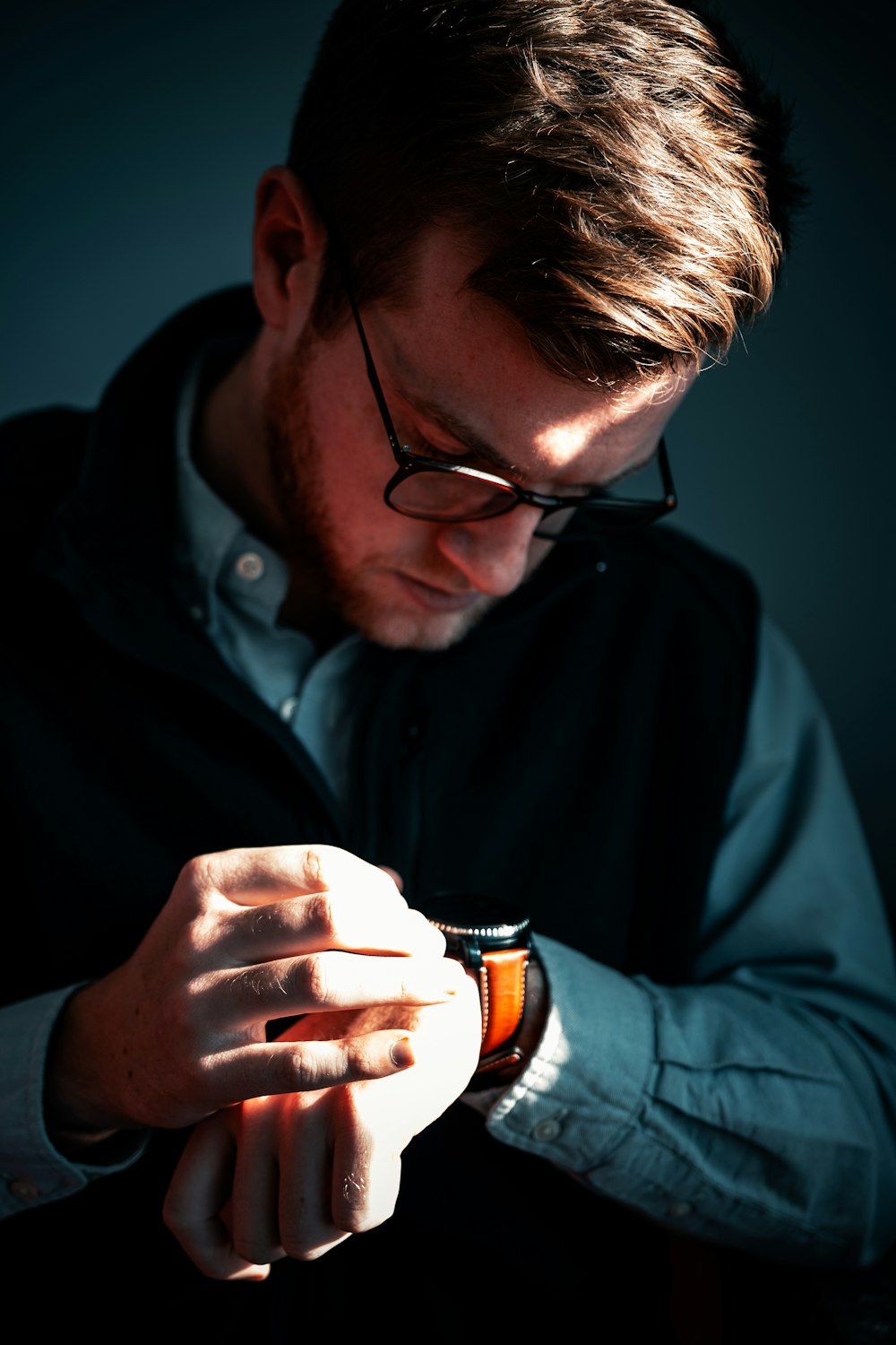 man in black jacket holding black and white ceramic mug