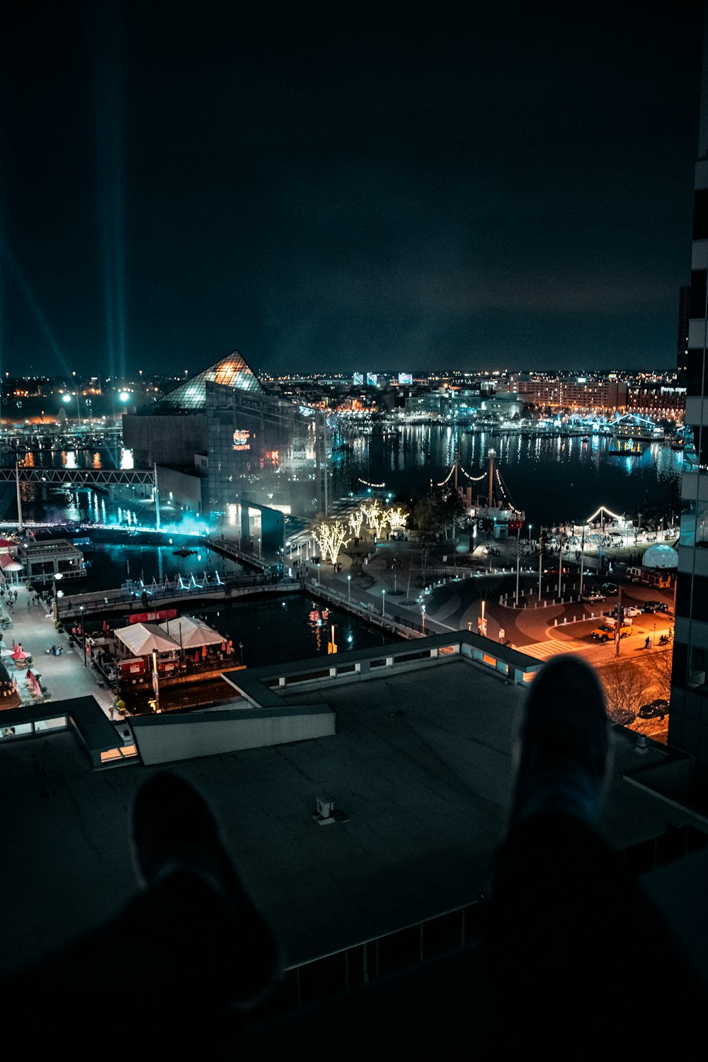 person in black pants sitting on gray concrete floor during night time