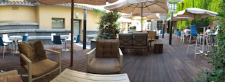 A vibrant outdoor patio rug laid out beneath a shaded seating area.