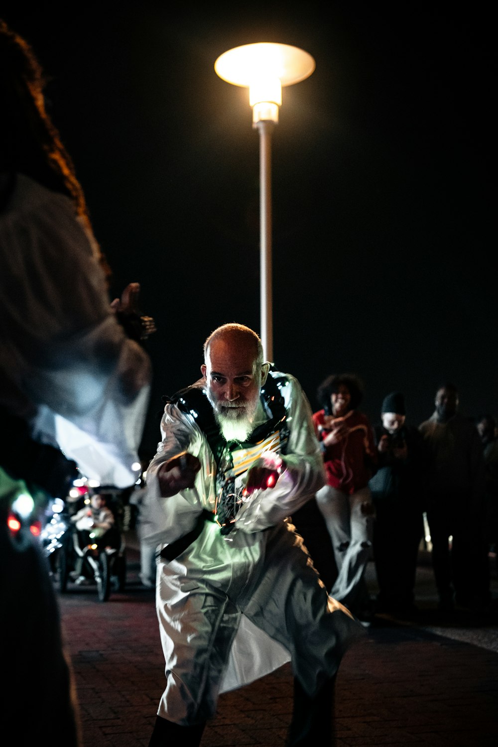 man in white and green costume standing on street during nighttime