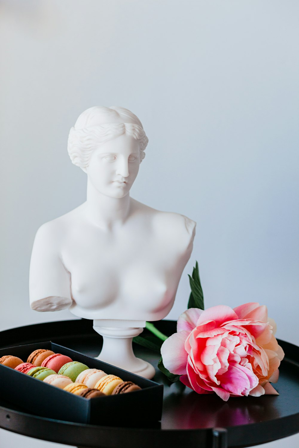 weiße Keramik Damenfigur neben roter Rose