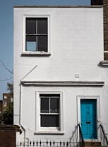 blue wooden door on white concrete building