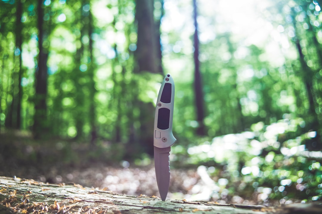 white and black knife on brown tree log