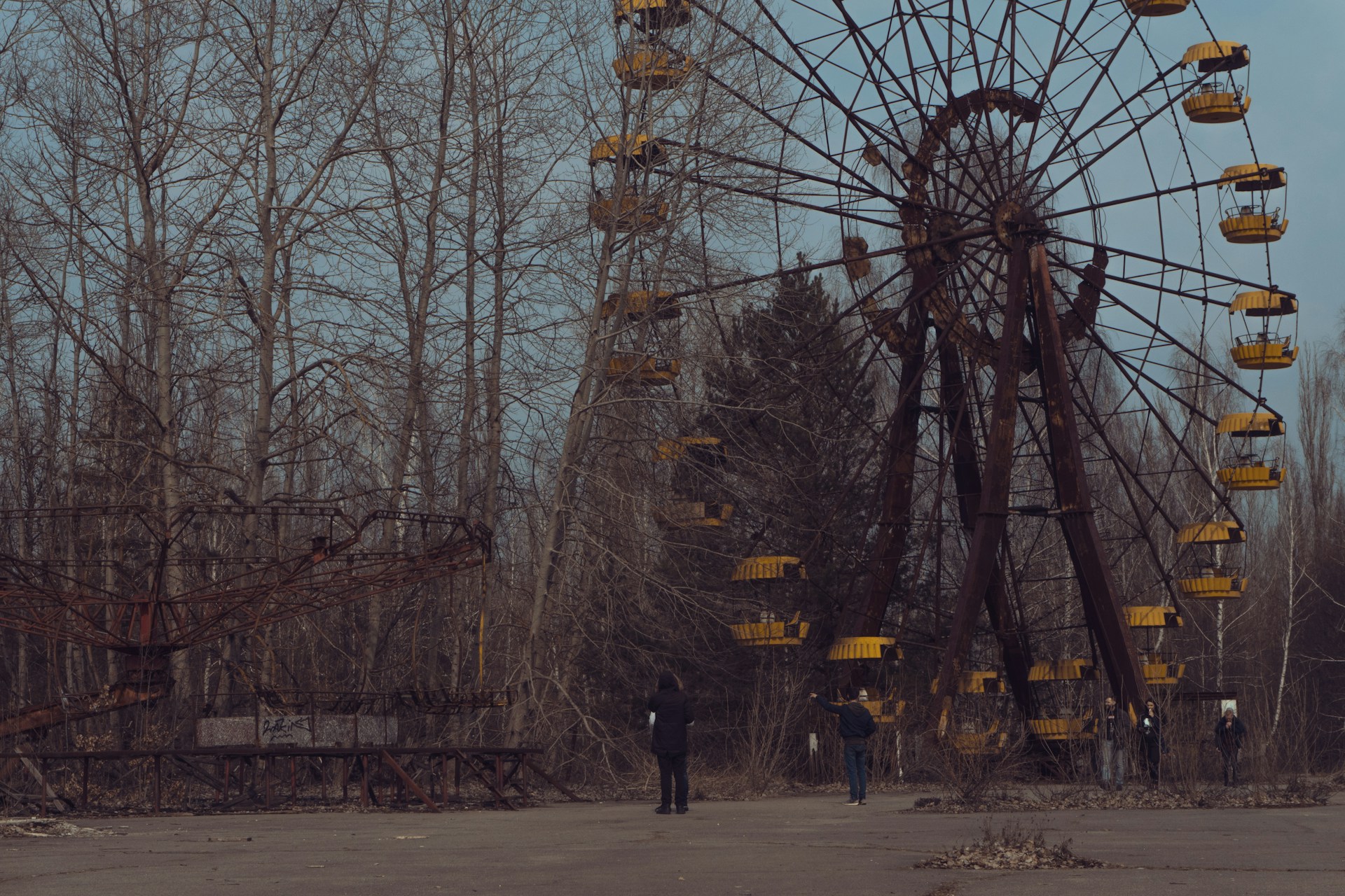 person in black jacket standing near ferris wheel during daytime