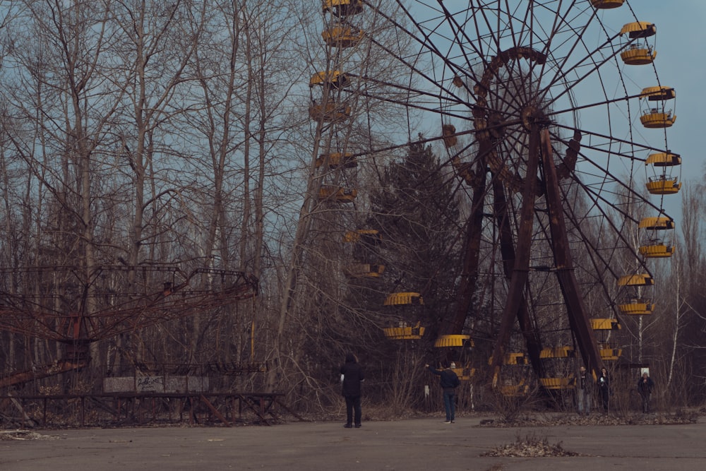 person in black jacket standing near ferris wheel during daytime