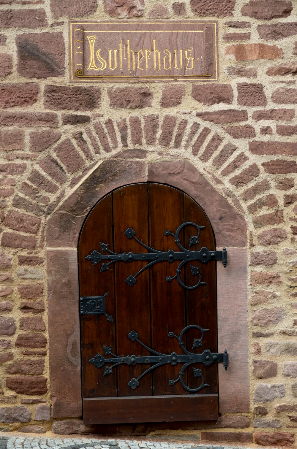 brown wooden door on brick wall