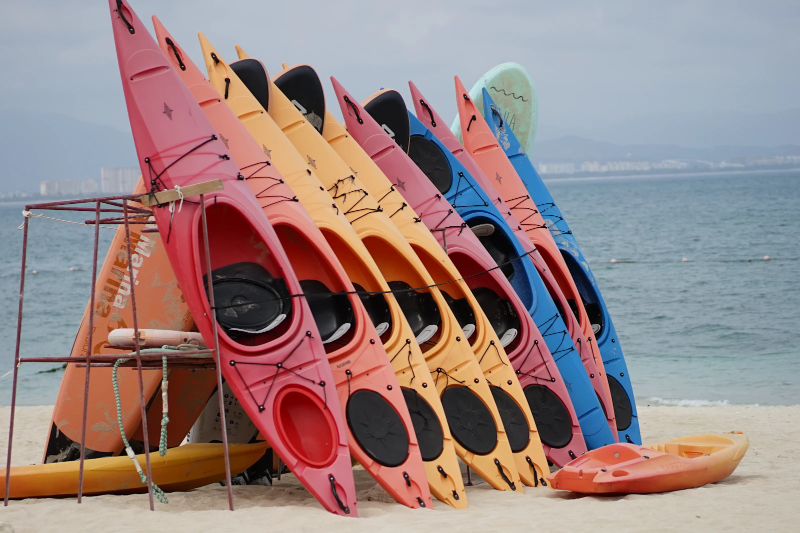Colorful rental kayaks racked up on a beach