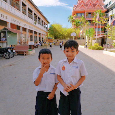 A group of boys wearing crisp navy blue school uniforms playing on the playground.