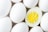 A close-up view of several white eggs with one egg halved to reveal its bright yellow yolk and firm white egg white.