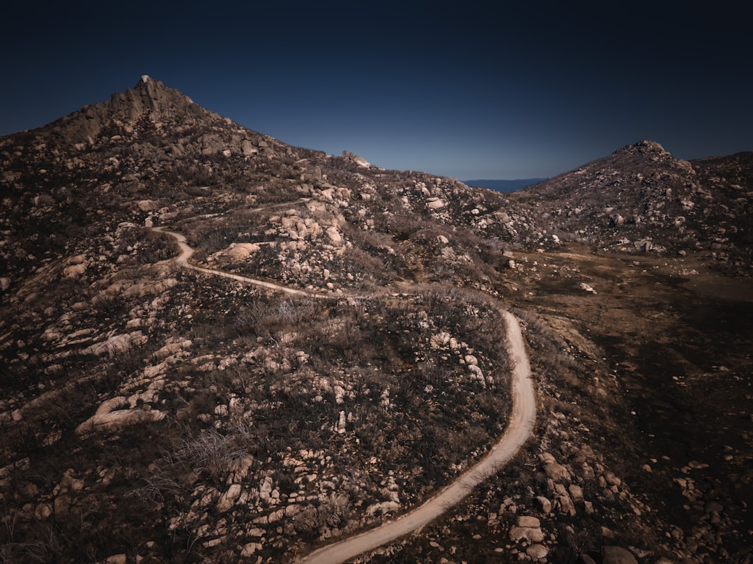 gray road in the middle of brown and gray mountains