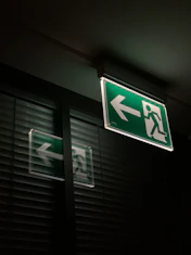 white and green emergency exit sign
