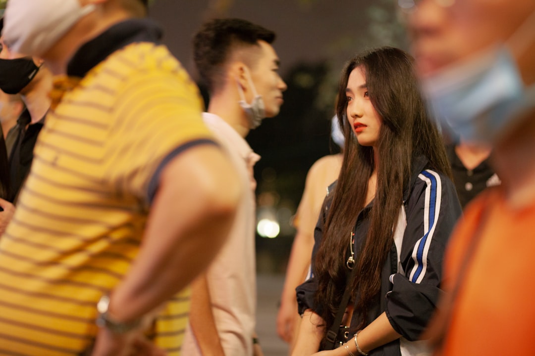 man in yellow and blue striped shirt kissing woman in black jacket