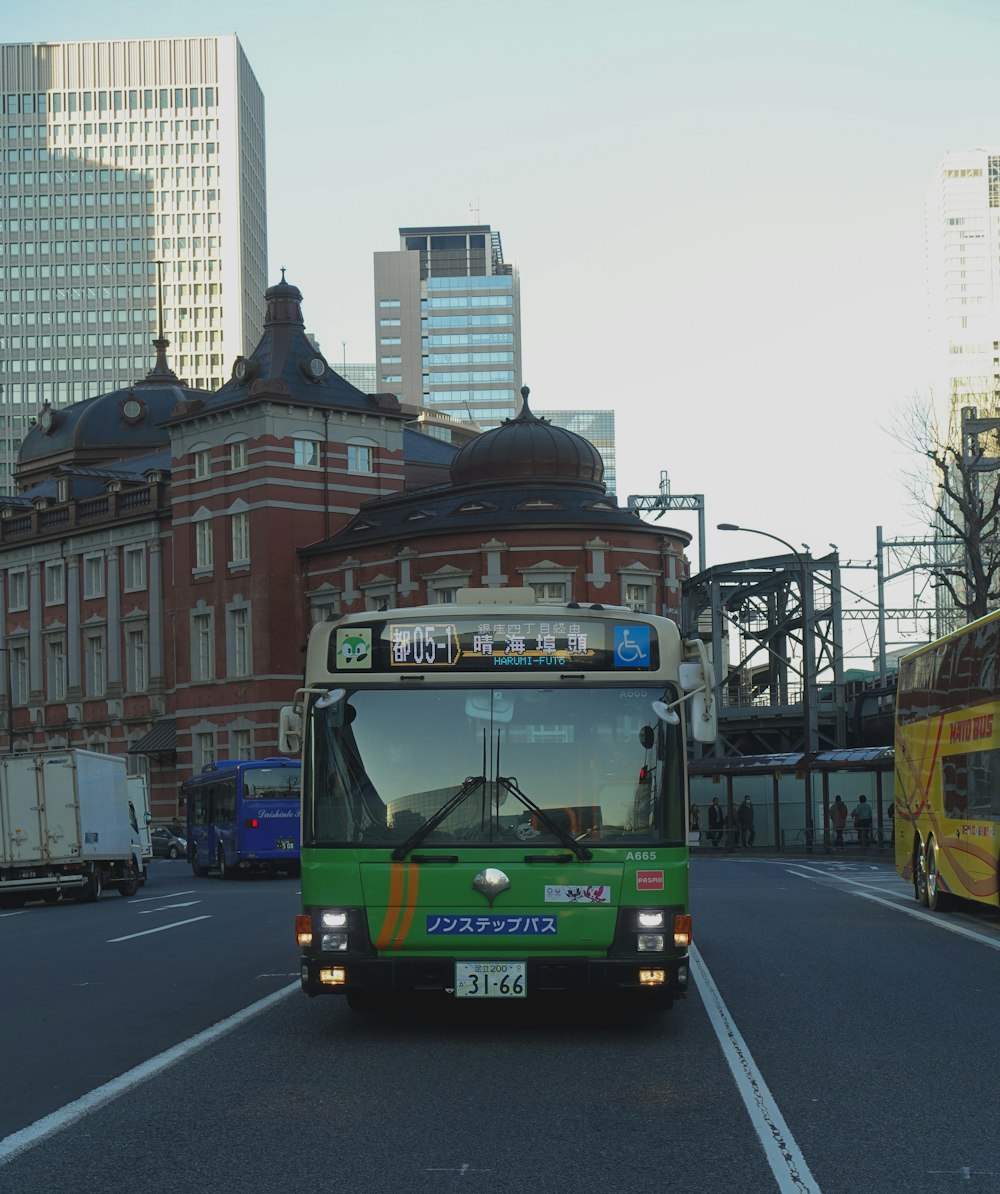 green bus on road near building during daytime