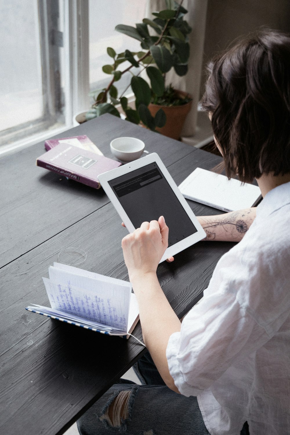 woman in white shirt holding white ipad