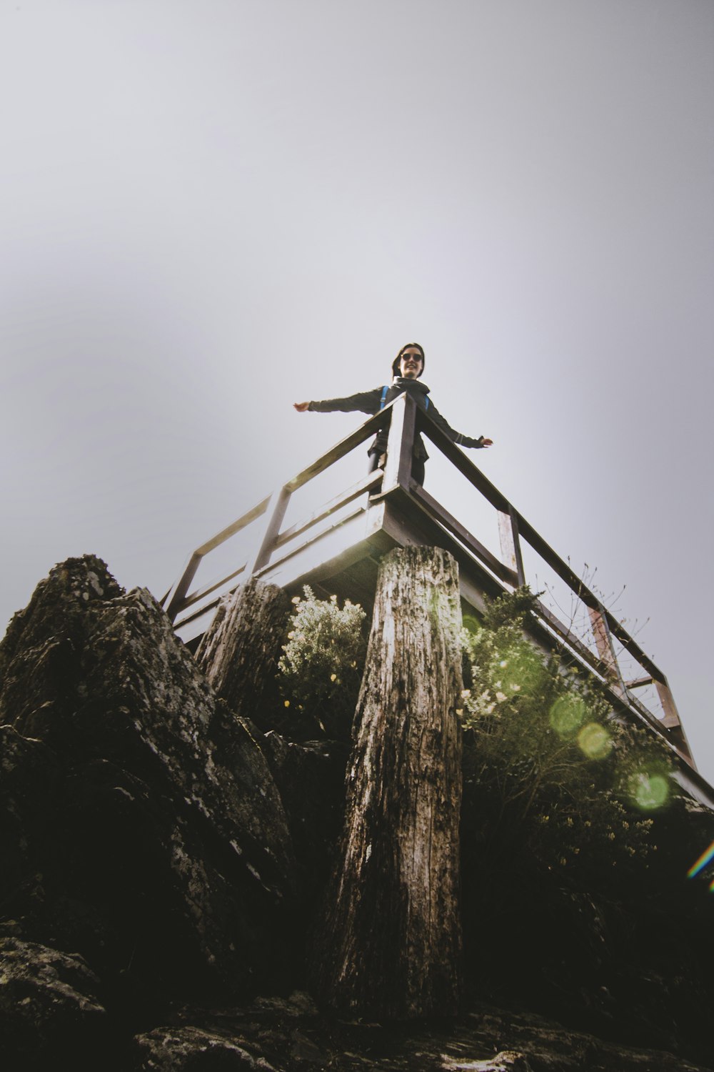 man in black jacket standing on brown wooden ladder