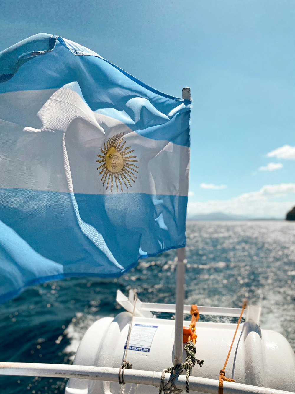 blue and white flag on white metal pole during daytime