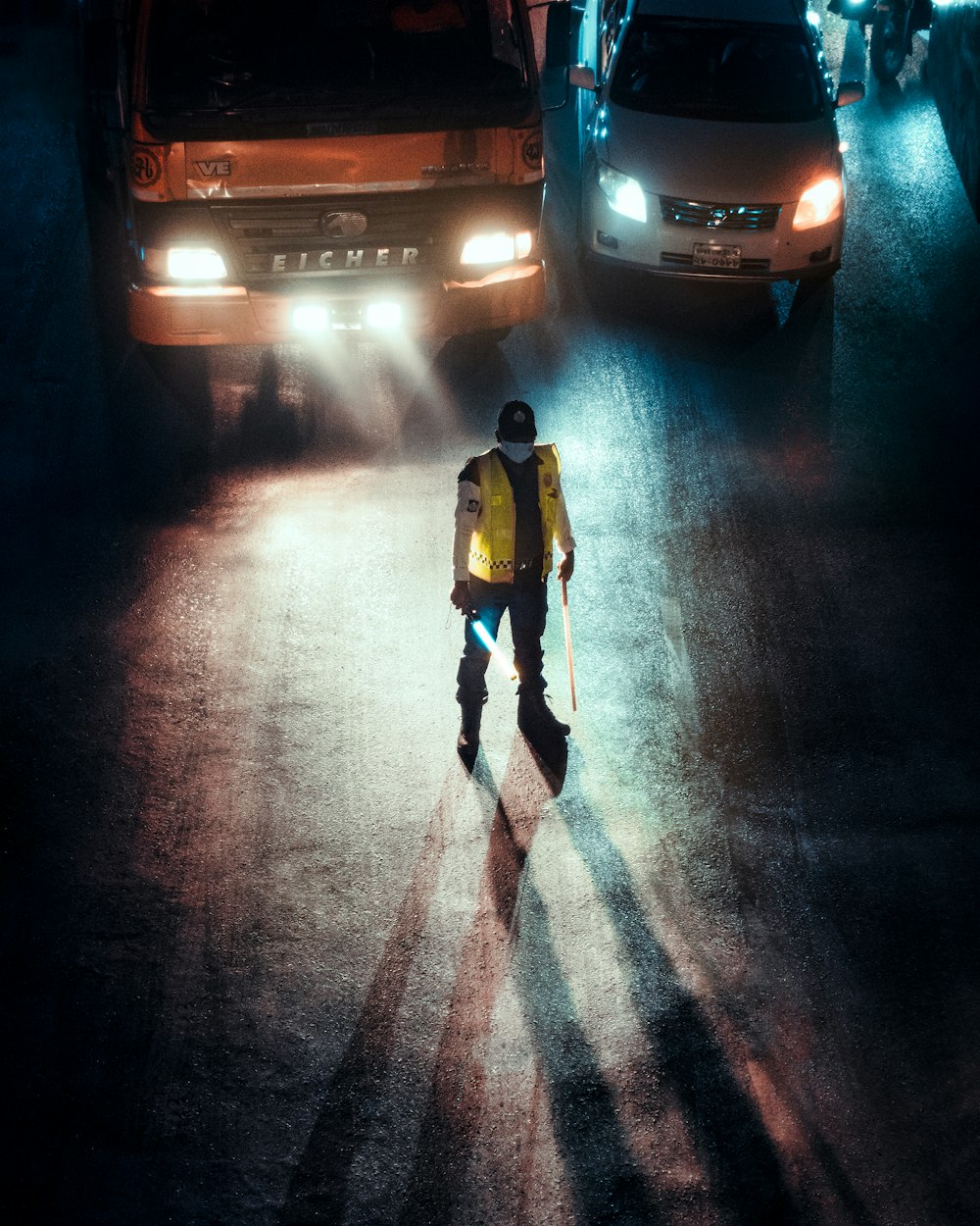 man in black jacket and black pants standing on road during night time