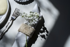 stainless steel fork and bread knife on white table cloth