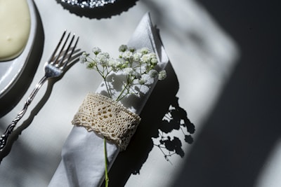An elegant napkin holder with folded white linen napkins sitting on a dining table.