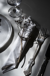 Polished silver cutlery set resting on a crisp white linen napkin.