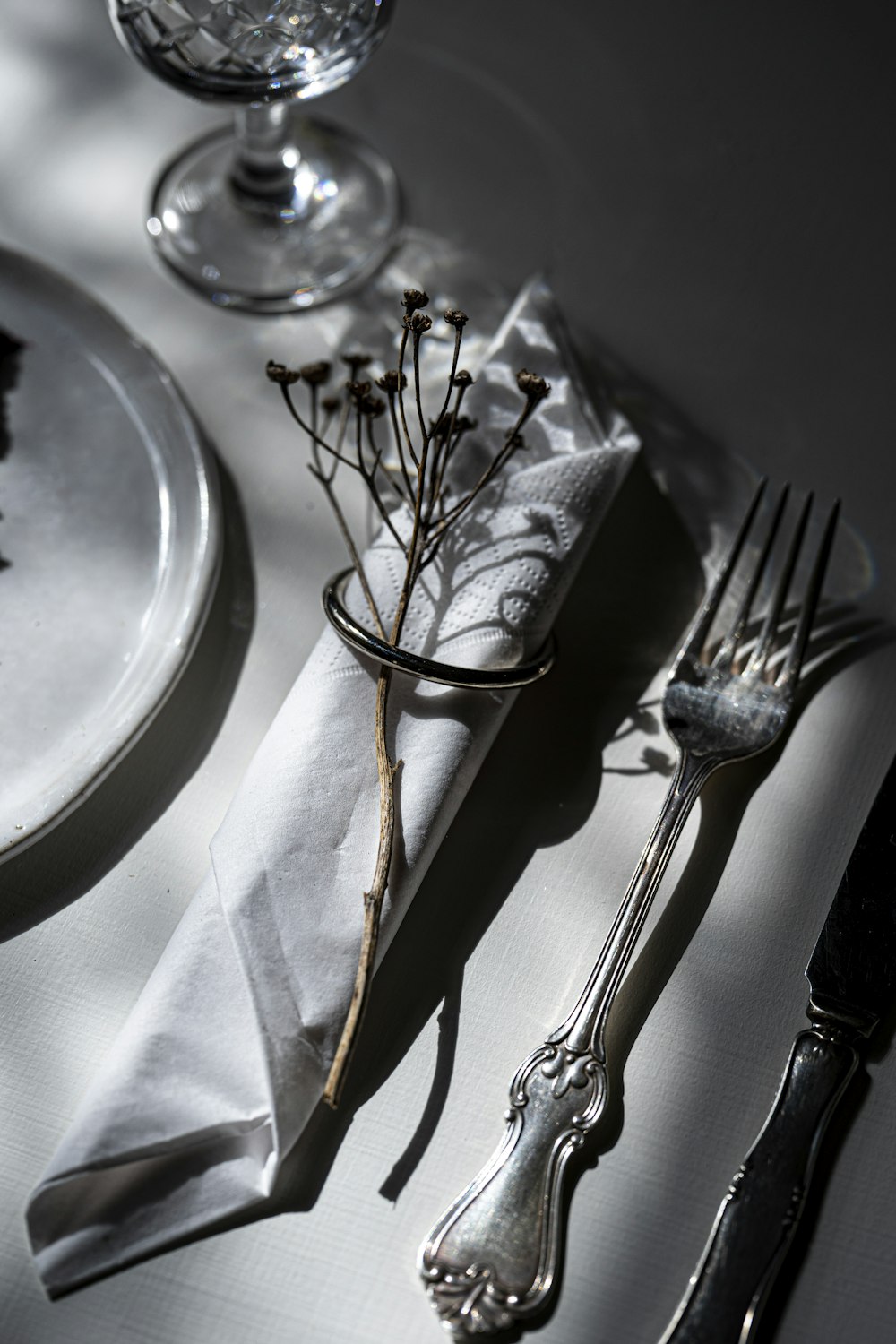 stainless steel fork and bread knife on white ceramic plate