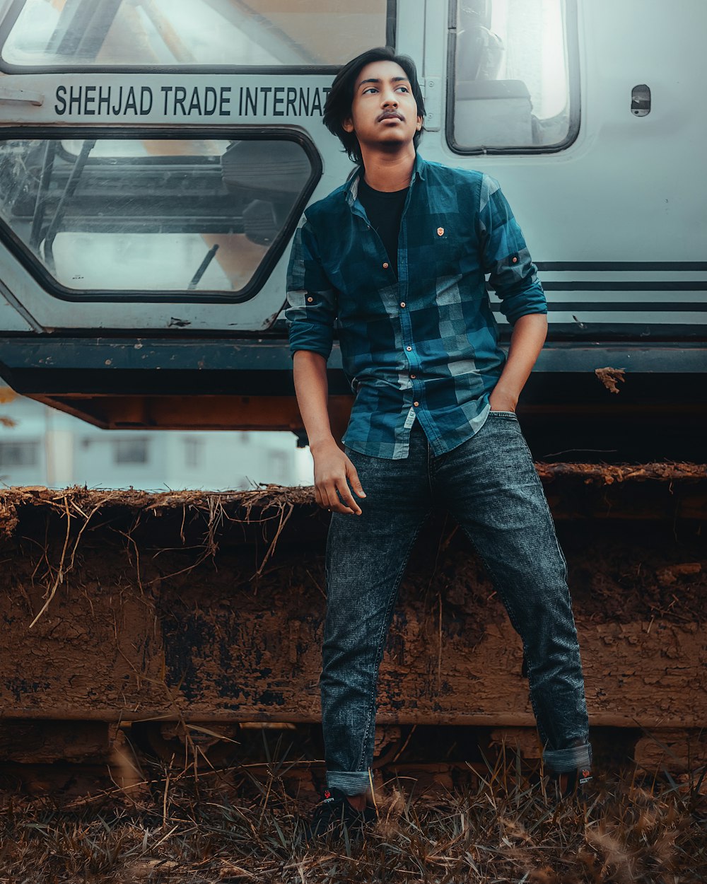 man in blue and black camouflage jacket and blue denim jeans standing beside white car during