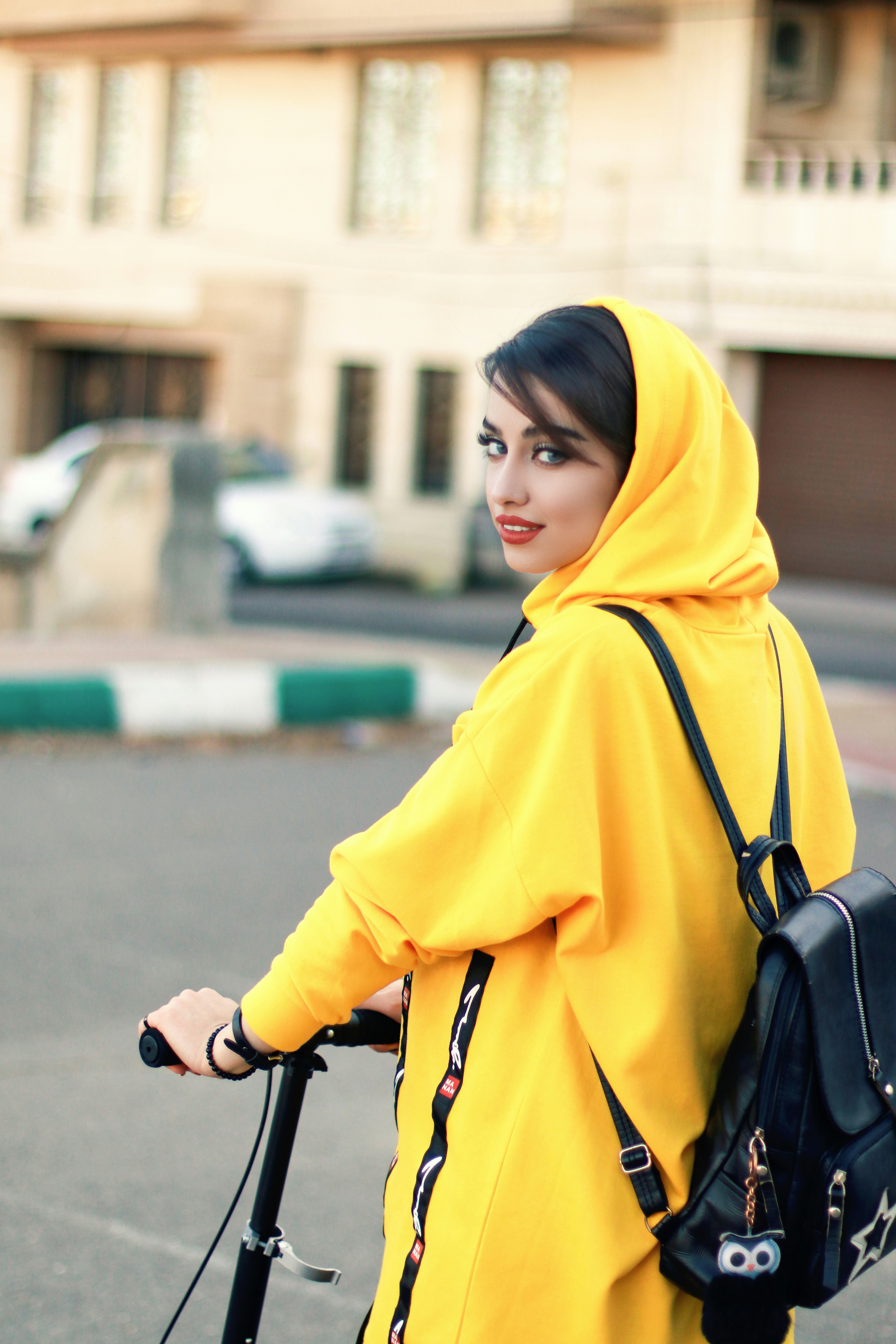 wanita berhijab kuning dan tas selempang kulit hitam