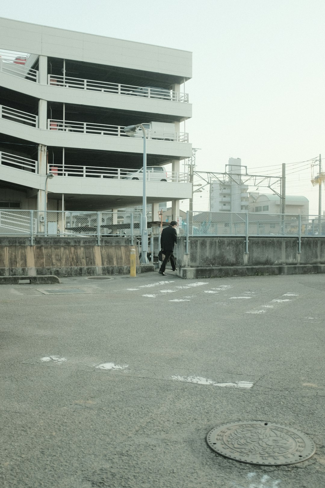 man in black jacket walking on sidewalk during daytime