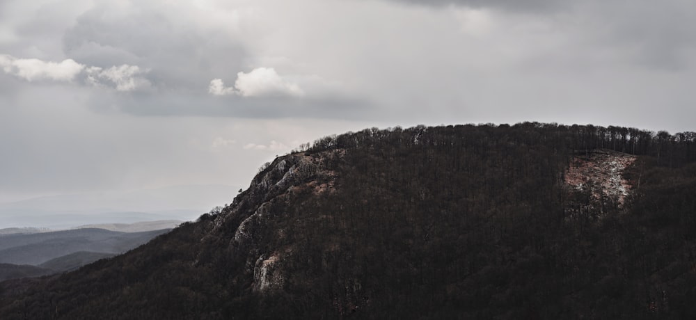 brown and green mountain under white clouds during daytime