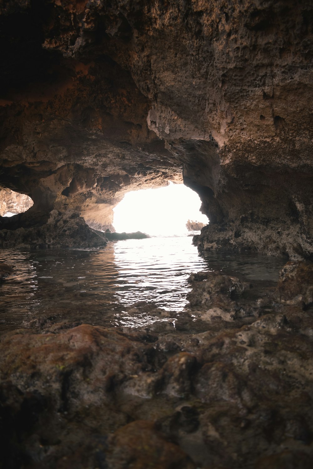 brown rock formation on body of water during daytime