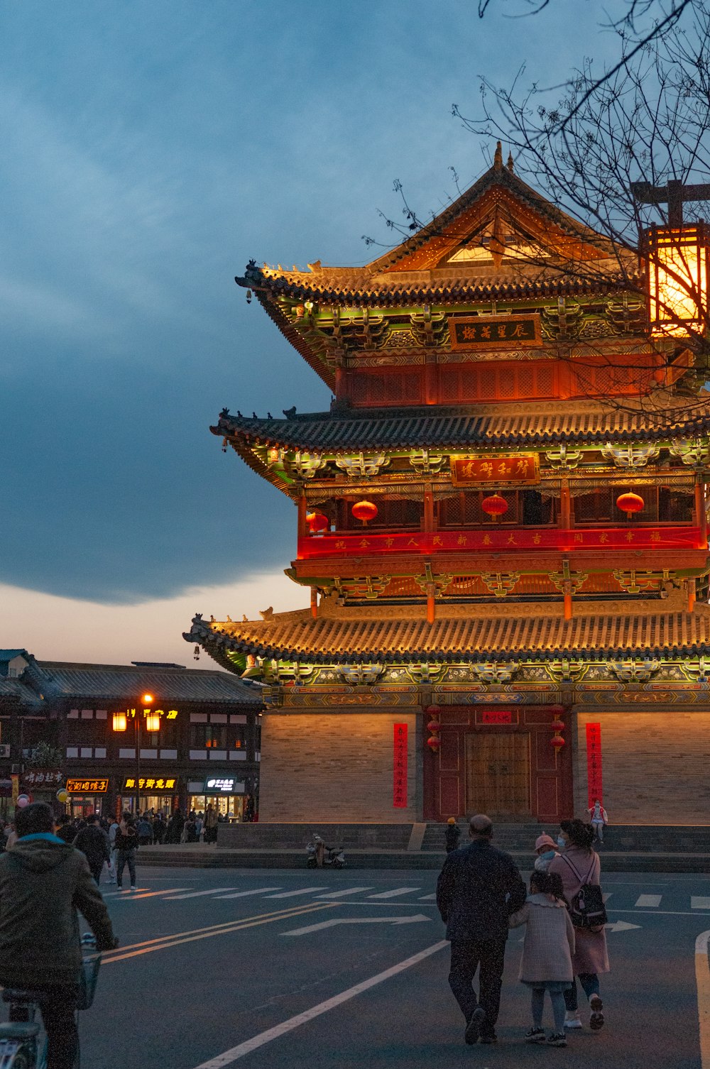 people walking on street near red and brown temple during night time