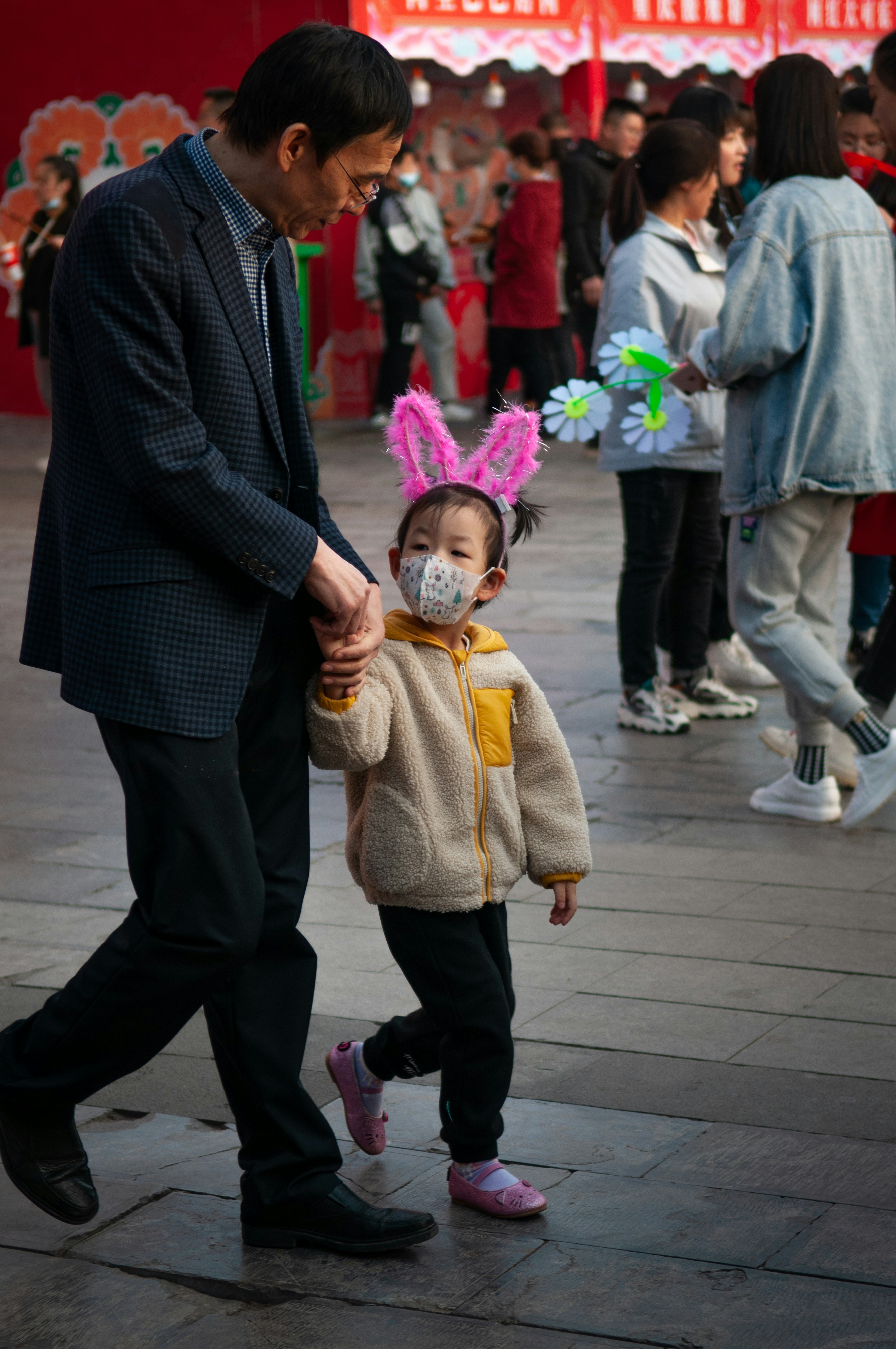 uomo in abito nero che trasporta ragazza in cappotto marrone