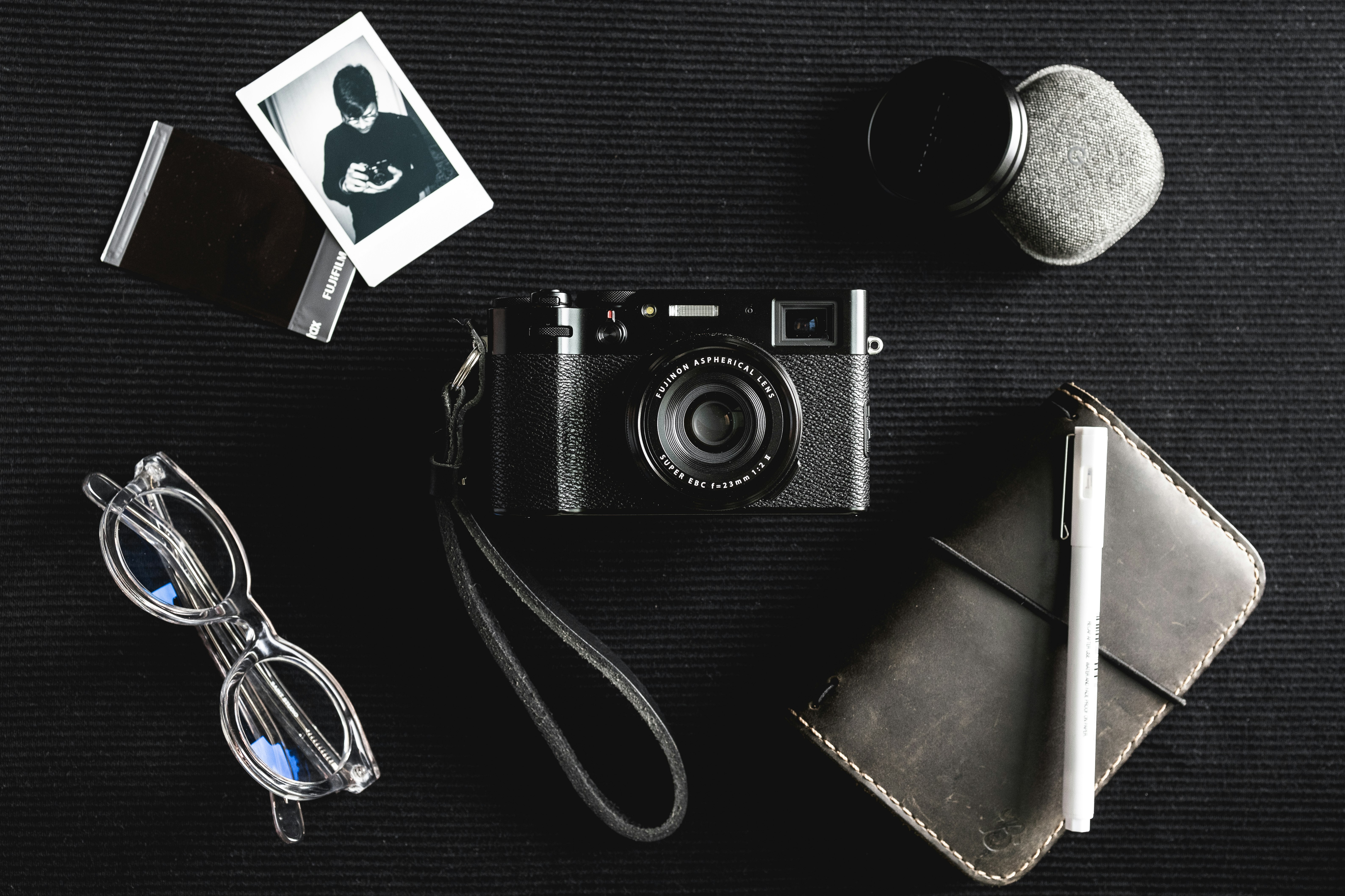 black and silver camera beside black leather bifold wallet