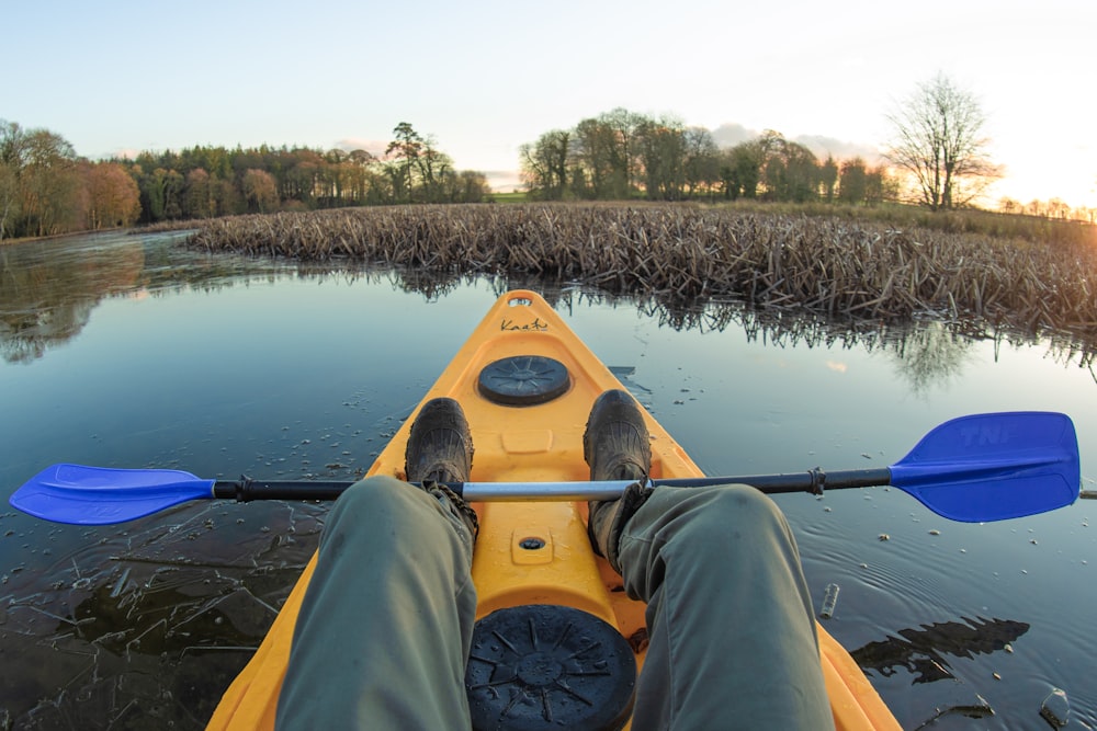 person in yellow kayak on lake during daytime