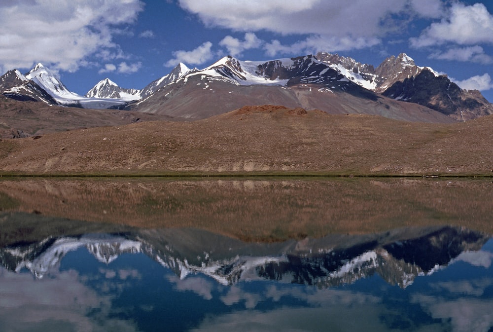 snow covered mountain near lake during daytime