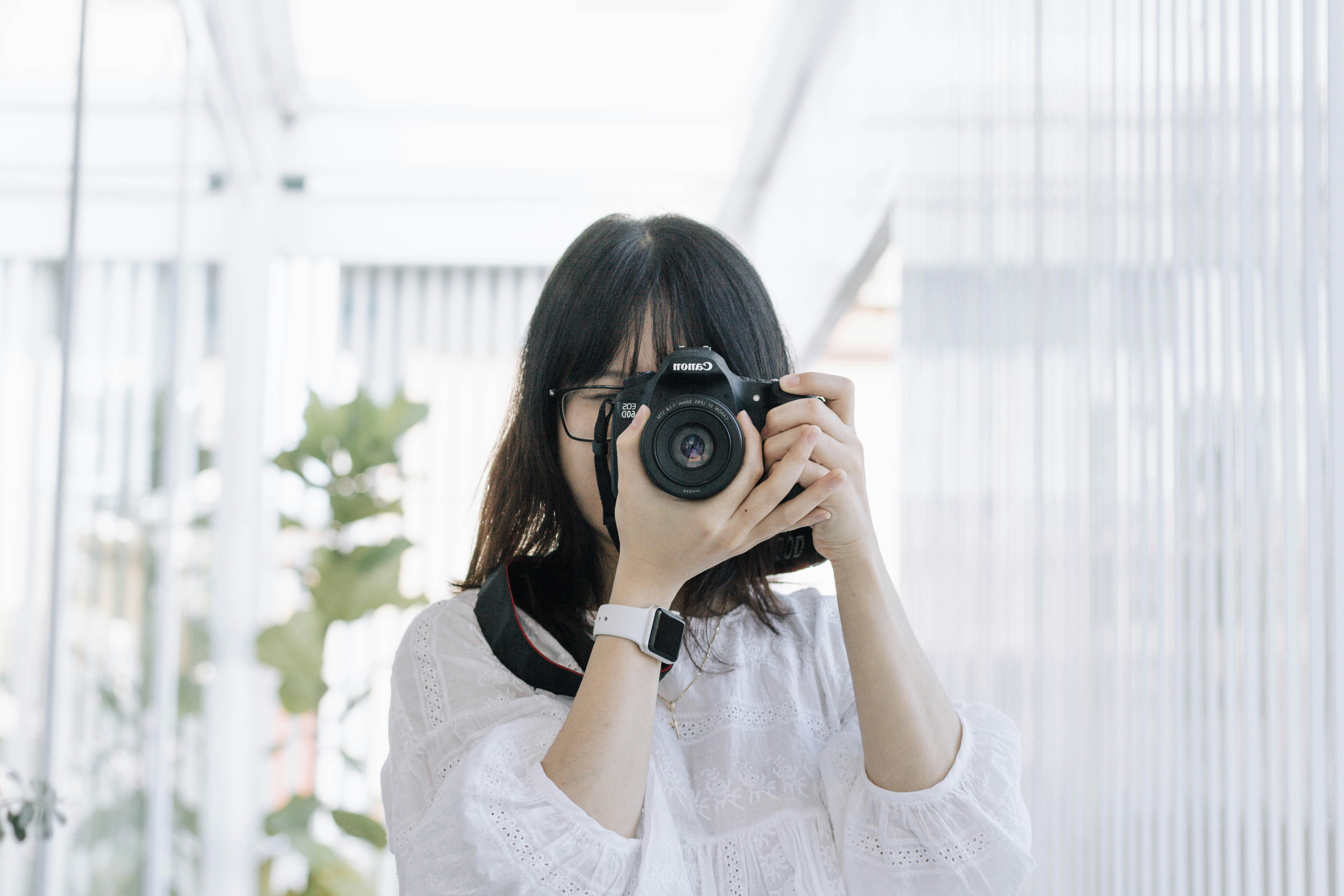 woman in white shirt holding black camera