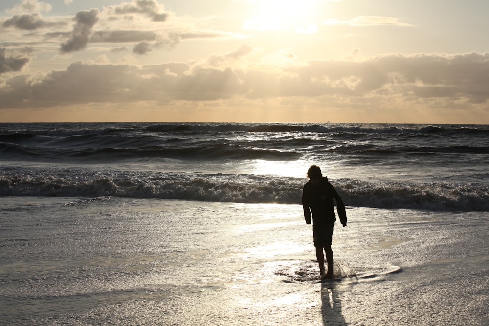 man and woman standing on beach during daytime