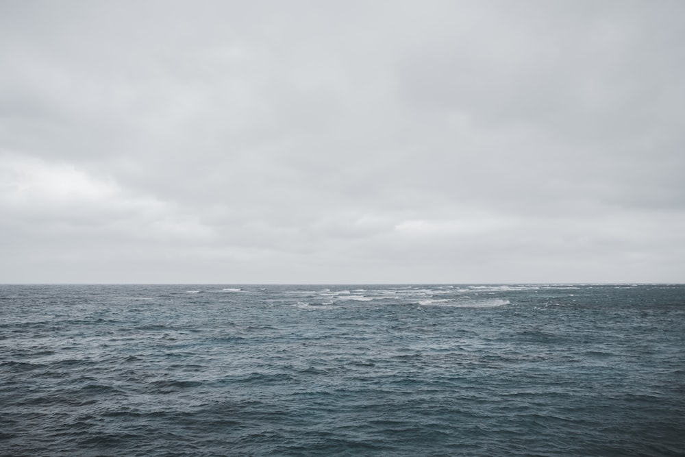 body of water under white sky during daytime