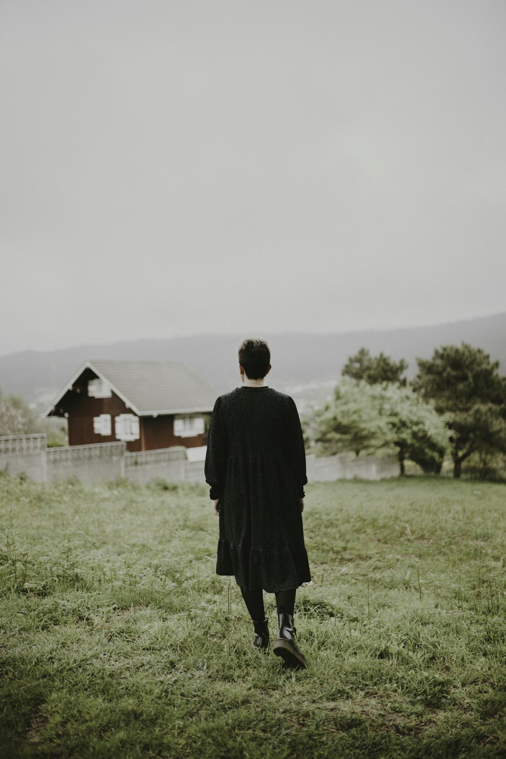 man in black coat standing on green grass field during daytime