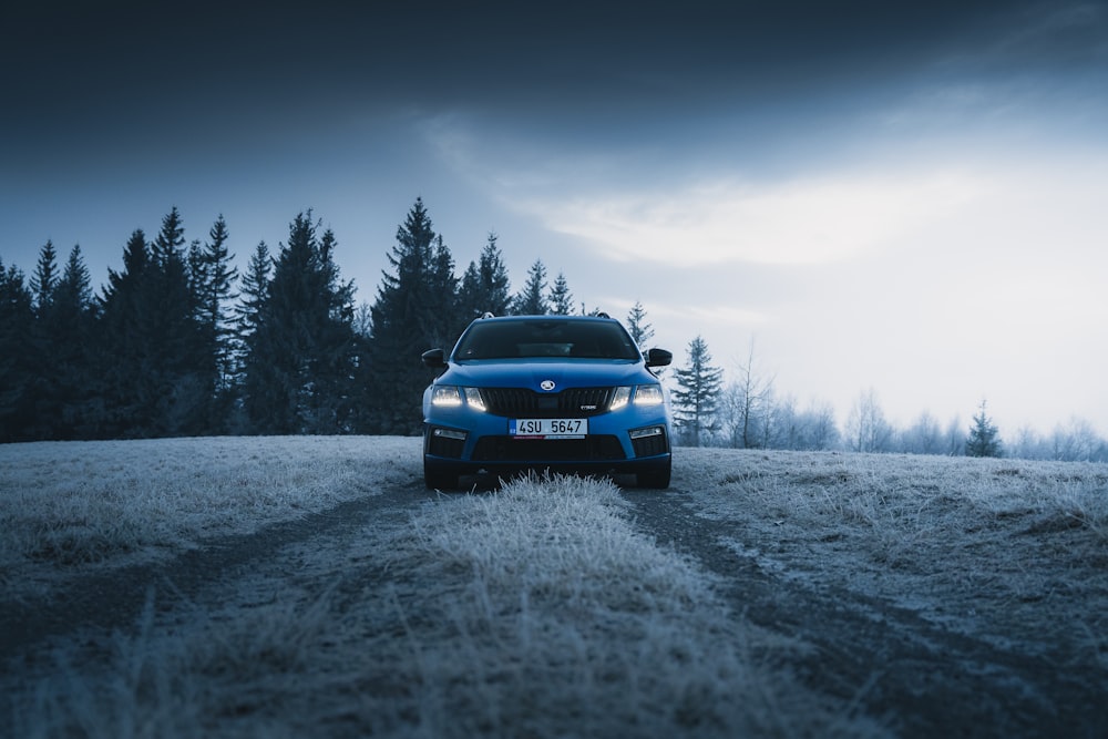 Voiture bleue sur un champ enneigé pendant la journée