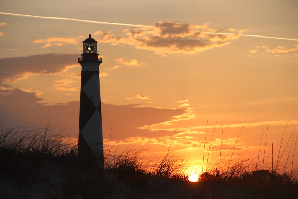 silhouette of lighthouse during sunset