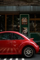 red car parked in front of store