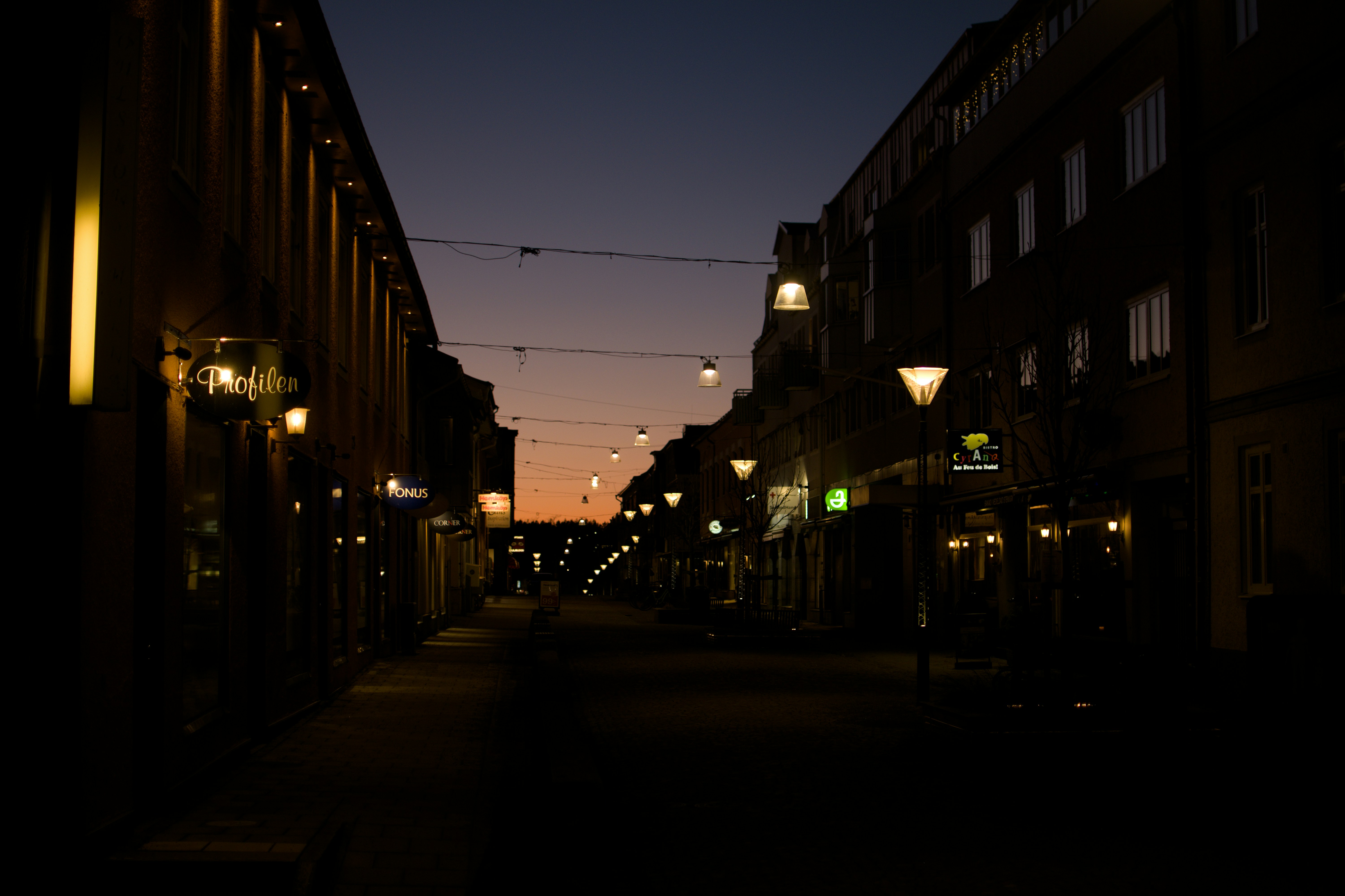 people walking on sidewalk during night time