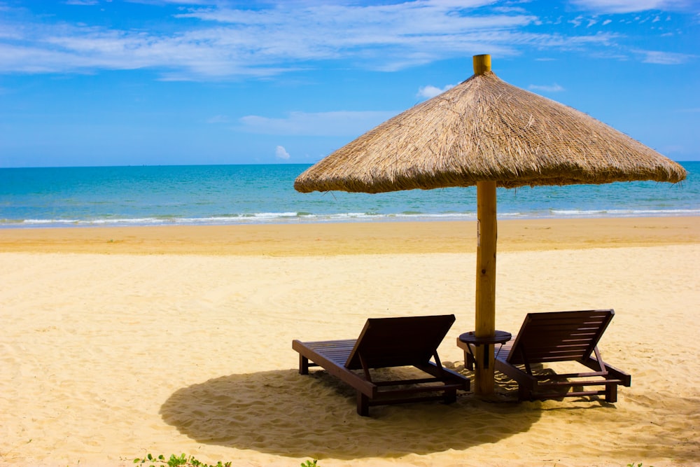 brown wooden beach lounge chairs on beach during daytime