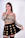 A stylish woman in a shimmering gold party dress smiling confidently at a glamorous event.